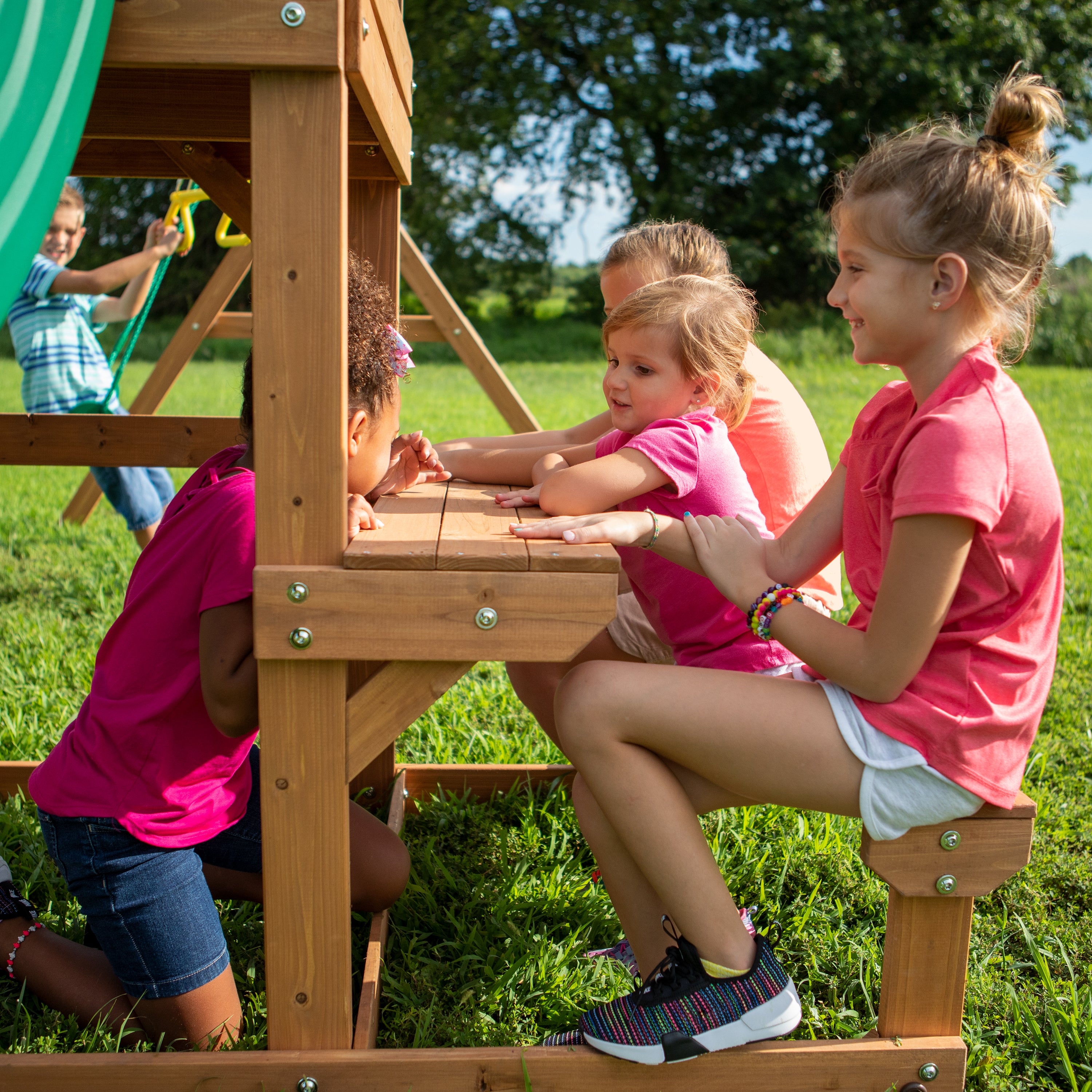 Children playing at built-in snack stand on Belmont wooden swing set in backyard